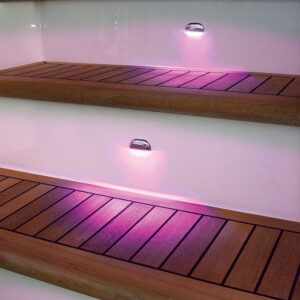 Purple coloured light illuminates wooden boat steps.